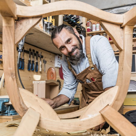 caucasian carpenter at work in a workshop building a chair