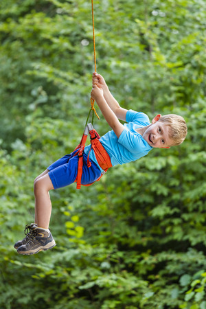 kid enjoy climbing tree in adventure park