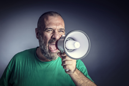 portrait of caucasian man with megaphone studio shotの写真素材