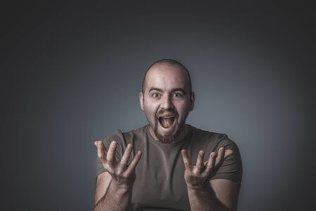 studio shot of a man with a surprised and enthusiastic expression with open hands in front of him