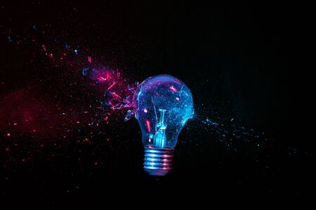 real explosion of a tungsten filament bulb. high speed photography. black background. concept of...