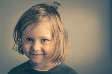 studio portrait of a 4 year old girl posing making funny face.の写真素材