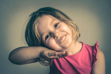 studio portrait of a 4 year old girl posing making funny face.の写真素材