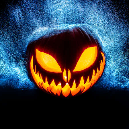 carved halloween pumpkin with bright point lights in the background.の写真素材