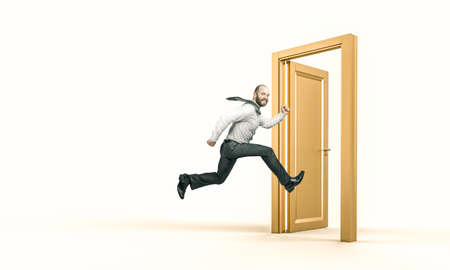 smiling businessman runs and enters a gold door. success concept.