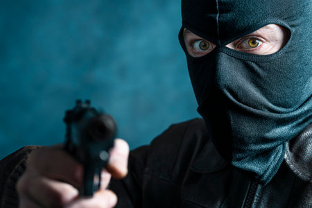 portrait of a thief with balaclava and gun. crime conceptの写真素材