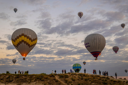 GOREME / TURKEY - June 30, 2022: tourists watch the hot air balloon show above goreme at dawnのeditorial素材