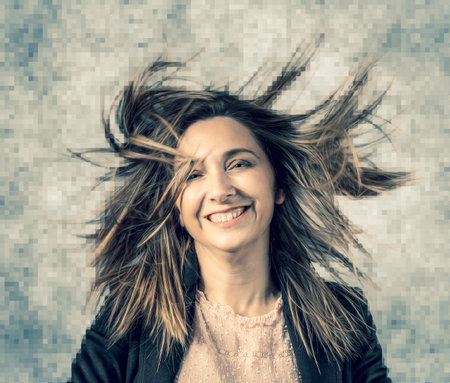 portrait of smiling woman and fluttering hair, geometric pixelated background