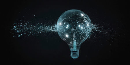 large filament bulb shatters on black background