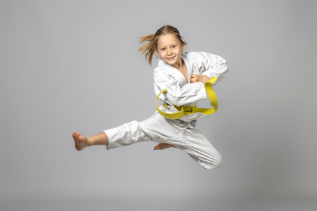 happy child practicing martial arts performs a jump, studio shotの写真素材