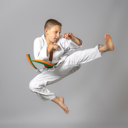 boy performs at jump martial arts practice, studio shotの写真素材