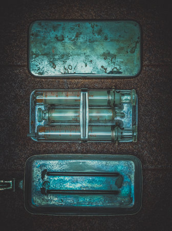 medical kit with antique glass syringe on metal backgroundの写真素材