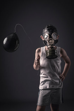 child with gas mask and black balloon, studio shotの写真素材