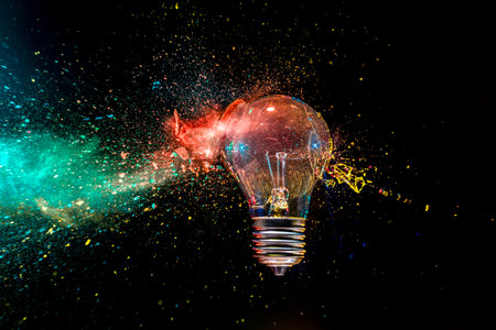 real image Light bulb exploding colorful powder black background creativity conceptの写真素材