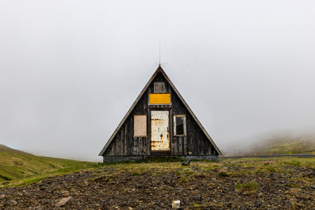 Small abandoned a frame wooden hut standing on foggy dayの写真素材