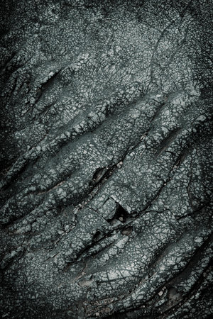 Dark gray cracked lava stone texture backgroundの写真素材