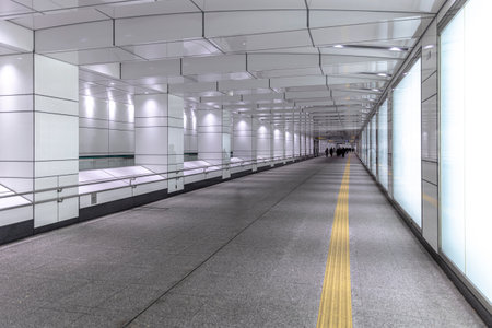 Modern empty subway corridor with tactile paving and illuminated panelsの写真素材