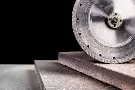 Diamond circular saw blade cutting concrete tiles black backgroundの写真素材