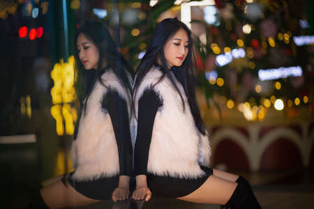 Ho Chi Minh city, Viet Nam: Beautiful Vietnamese girl walking in the street at nightの写真素材