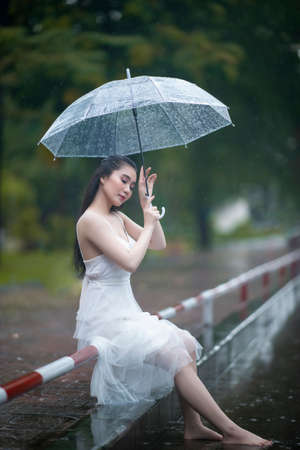 Ho Chi Minh city, Viet Nam: Vietnamese girl posing in the rainの写真素材