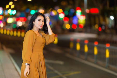 Ho Chi Minh city, Viet Nam: Beautiful Vietnamese girl walking in the street at nightの写真素材