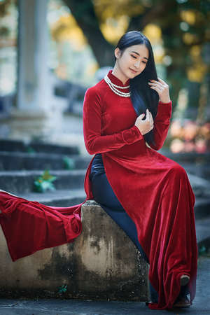 Ho Chi Minh City, Vietnam - March 1, 2021: Portrait of a beautiful girl in a red ao dai