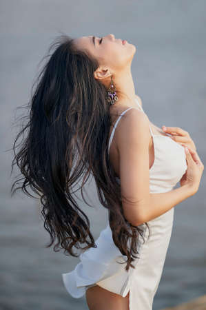 Ho Chi Minh City, Vietnam: Vietnamese girl in extremely sexy clothes, walking in the grassland at sunsetの写真素材