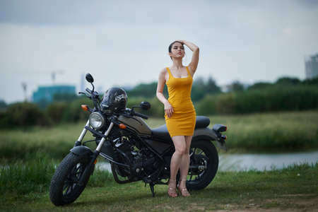 Ho Chi Minh City, Vietnam: Portrait of a very attractive Vietnamese girl next to a large displacement vehicleの写真素材