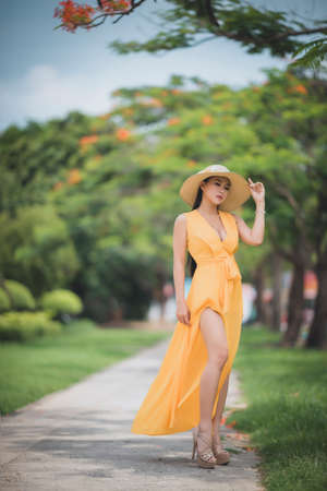 Ho Chi Minh City, Vietnam: Portrait of a Vietnamese girl in a long yellow dressの写真素材