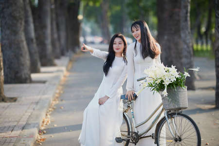 Ho Chi Minh City, Vietnam: The beautiful and pure friendship of two Vietnamese schoolgirls in white ao daiの写真素材