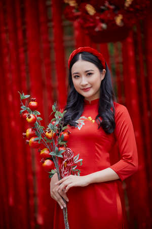 Ho Chi Minh City, Vietnam: Portrait of a brilliant Vietnamese girl in a red ao dai to welcome the...