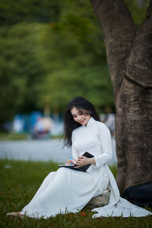 Ho Chi Minh City, Vietnam: a beautiful Vietnamese student in white ao daiの写真素材