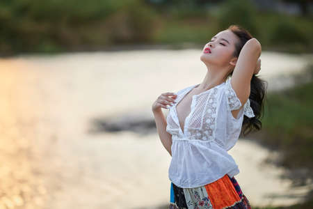 Ho Chi Minh city, Viet Nam: beautiful girl by the lake in the sunsetの写真素材