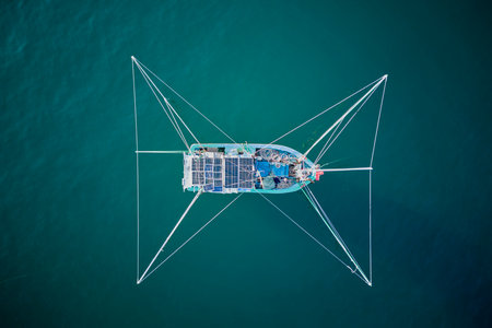 Aerial drone view of a fishing boat with solar panels in the seaの写真素材