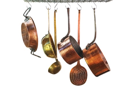 saucepans hanging from a rack in a traditional style kitchenの写真素材