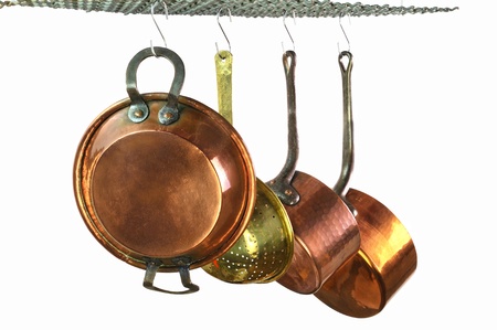 saucepans hanging from a rack in a traditional style kitchenの写真素材