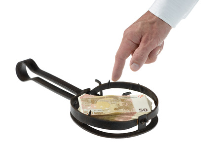 People hand trapped while catching the money placed on the animal trapの写真素材