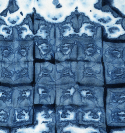 Background tie-dye pattern of indigo color on white silk. Hand painting fabrics - nodular batik. Shibori dyeing.の写真素材