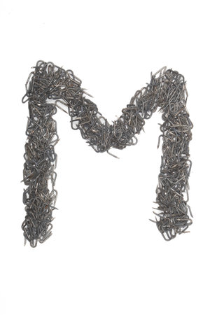 artistic isolated Letter M made from steel staples isolated on a white background write, font, type style,の写真素材