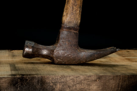 close up of hammer on wood with black background with reduced vibrance, grungy, old, antique, vintageの写真素材