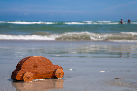 wooden toy car at beach, going on vacation, going to the beach, destination, drive, road trip to the beach, with copy spaceの写真素材