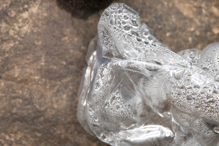 Close up of the condensation in a plastic water bottle lying in the rocks.