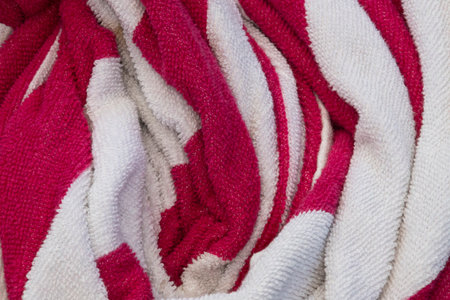close up, white and pink striped towel bunched up, high contrast, heavy texture, background,...