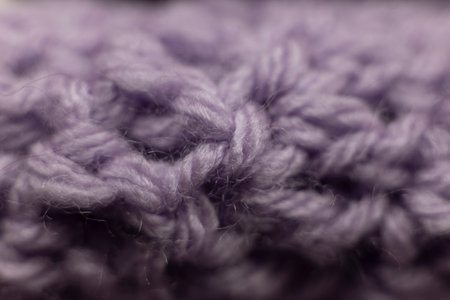 close-up of crochet stitches of a lilac purple blanket, crocheted or knitted, reminds you of grandma's house, cozy and warm backgroundの写真素材