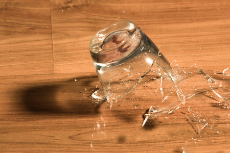 Breaking of a glass on a wood floor の写真素材