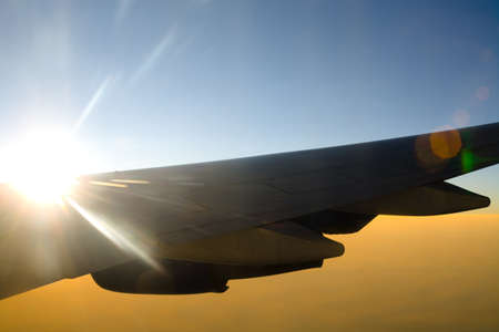 Aircraft wing against the sun with flare