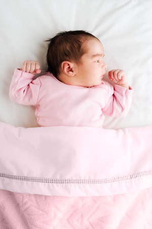 Newborn baby girl on her bed