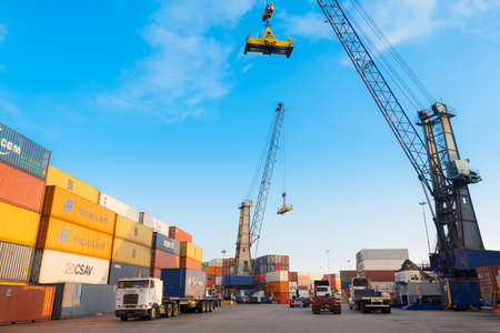 Iquique, Tarapaca Region, Chile - Tower cranes loading trucks with containers at the Port of Iquique.のeditorial素材