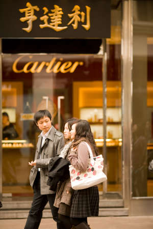 Shanghai, Huangpu district, China, Asia - Modern Chinese youth in front a Cartier store shopping at...
