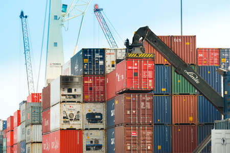 Iquique, Tarapaca Region, Chile - Crane fork loading cargo ship with containers at the Port of Iquique.のeditorial素材